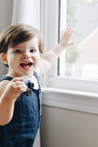 18 Month old Noah standing in front of a window. What's wrong?